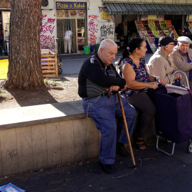 Varios pensionistas sentados en un banco en una plaza en Roma. REUTERS / Max Rossi