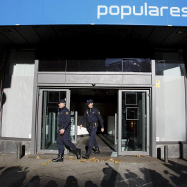 Dos agentes de Policía salen de la sede del PP en la madrileña calle de Génova, tras el registro realizado en diciembre de 2013 durante 14 horas en busca de documentación sobre el pago en B de las obras del edificio, en . REUTERS/Paul Hanna