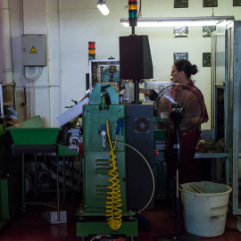 Una trabajadora maneja maquinaria en una fábrica de corchos en Girona, a 16 de junio de 2022.