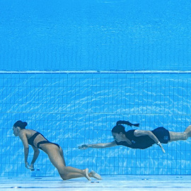 Un miembro del Equipo de EE. UU. (R) nada para recuperar a Anita Alvarez (L) de EE. UU., Del fondo de la piscina durante un incidente en las finales de natación artística libre en solitario de mujeres, durante el Campeonato Mundial Acuático de Budapest