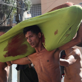 Personas cargan un cadáver durante una operación policial contra bandas de narcotraficantes en el complejo de favelas de Alemao, en Río de Janeiro