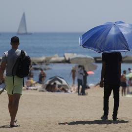 15/07/2022-Dos personas pasean por la Barceloneta el viernes 15 de julio, en Barcelona