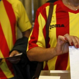 Una ciudadana deposita su voto en una mesa de en un colegio electoral de Barcelona durante el referéndum que tuvo lugar el 9-N del año 2014.- EFE