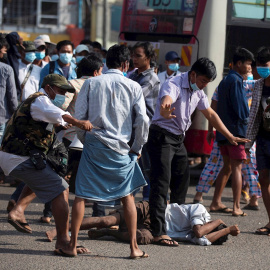 Un residente Yangon (Myanmar) cae al suelo mientras simpatizantes promilitares atacan a los residentes con honda y proyectiles