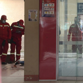 Varios bomberos inspeccionan el lugar del accidente el que murieron varios estudiantes de la Universidad de El Alto (Bolivia).