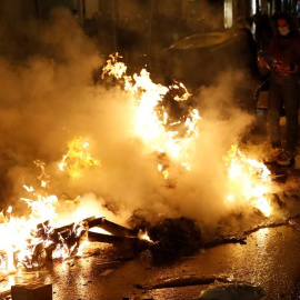 Restos de contenedores ardiendo en el centro de Barcelona este sábado, durante las protestas por el encarcelamiento del rapero Pablo Hasél.