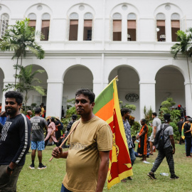 Un hombre sostiene la bandera de Sri Lanka durante la multitudinaria protesta.