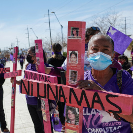 Mujeres sostienen cruces en la que se lee: "Ni una más" en Ciudad Juarez, México