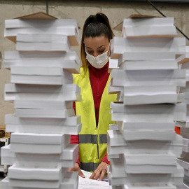 Una operaria organiza parte del material destinado a las elecciones autonómicas del 4 de mayo almacenado este martes en un centro logístico de Alcalá de Henares.