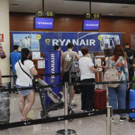 15/08/2022.- Varios pasajeros hacen cola ante uno de los mostradores de facturación en la Terminal 2 del Aeropuerto de Barcelona-El Prat este lunes.