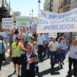 Varias personas sujetan una pancarta en la que se lee: 'El PP vende los servicios públicos' durante una marcha contra la reforma de la Ley de Transportes, a 1 de junio de 2022, en Madrid (España).