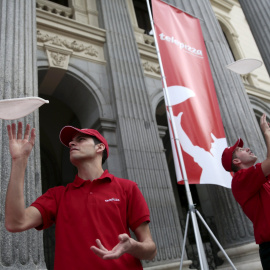 Los trabajadores de Telepizza lanzan la masa al aire en una demostración en la Bolsa de Madrid el primer día de cotización de la empresa.. REUTERS/Andrea Comas