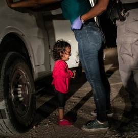 La niña Yana, de Honduras, llora mientras su madre, Sandra Sánchez, es cacheada por un policía estadounidense en la frontera en Texas./ JOHN MOORE (GETTY IMAGES)