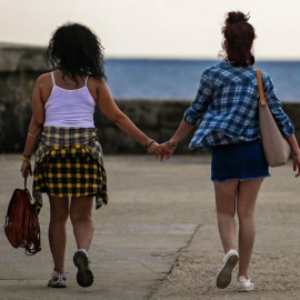 Una pareja andando por Malecón en La Habana