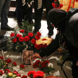 Una mujer coloca una foto de Franco sobre su tumba en el Valle de los Caídos. (REUTERS)