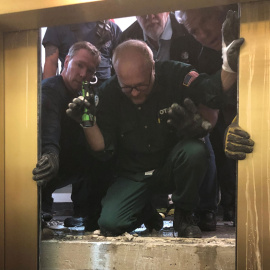 El equipo de rescate abre la puerta del ascensor donde quedaron atrapadas seis personas en Chicago. /REUTERS