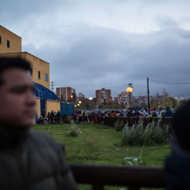 Cientos de solicitantes de asilo esperan la cola durante toda la noche para obtener un cita previa con la que comenzar sus trámites, en la comisaría de Extranjería de Aluche, Madrid. JAIRO VARGAS