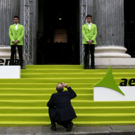 Un hombre saca una foto con su móvil en la entrada de la Bolsa de Madrid, el día en que Aena comenzó a cotizar en el mercado, en febrero de 2015. REUTERS