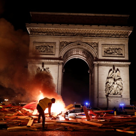 Un manifestantes de los llamados "chalecos amarillos" prende fuego a una barrica frente al Arco del Triunfo de París en la manifestación contra el alza de precio de los carburantes.- REUTERS/Benoit Tessier