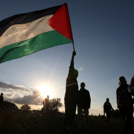 Manifestantes despliegan una bandera de Palestina durante una protesta junto a la frontera en Gaza. - REUTERS