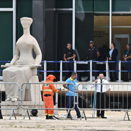 Trabajadores del servicio de limpieza urbana limpian el área cerca a sede de la Corte Suprema en la Plaza de los Tres Poderes este jueves en Brasilia (Brasil).