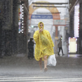 Un hombre camina por la calle bajo fuertes lluvias y vientos causados ​​por el tifón Nanmadol en Kagoshima, en la isla principal más al sur de Japón.