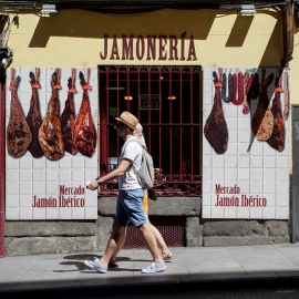 Una pareja de turistas pasa por delante de una jamonería en el centro de Madrid. REUTERS/Paul Hanna