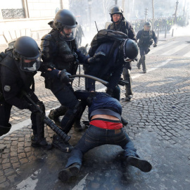 La Policía francesa golpea a un manifestante durante las protestas de los chalecos amarillos. REUTERS/Philippe Wojazer