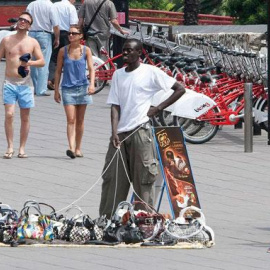 Un mantero vende objetos falsificados en el centro de Barcelona. EFE/Archivo