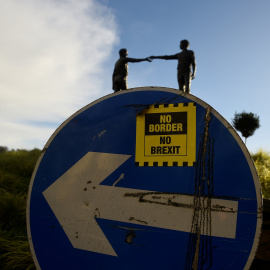 Una pegatina de 'No fronteras, no brexit', en una señal de tráfico frente a la estatua de la Paz titulada 'Hands Across the Divide' en Londonderry, Irlanda del Norte. REUTERS / Clodagh Kilcoyne