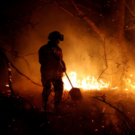 Los bomberos intentan sofocar el incendio en los alrededores de Labares | EFE/ José Luis Cereijido