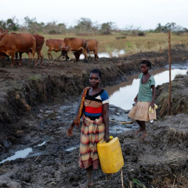 Varias mujeres desplazadas tras el paso del ciclón Idai recogen agua en Sofala. EFE