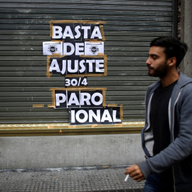 Un hombre para junto a un cartel que llama a la huelga, este martes en Buenos Aires. REUTERS/Agustín Marcarian