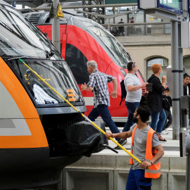 Un empleado del servicio limpia la ventana delantera de un tren en Alemania