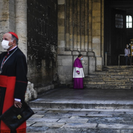 Imagen de archivo de un sacerdote con mascarilla espera al patriarca Manuel Clemente (izquierda) antes de celebrar la misa dominical en la catedral de Lisboa