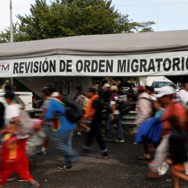 Migrantes de la caravana que viaja hacia EEUU pasan por un punto de revisión de orden migratorio. REUTERS/Carlos Garcia Rawlins