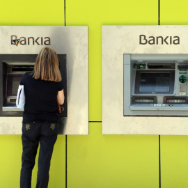 Una mujer opera en un cajero automático en una sucursal de Bankia en Madrid. AFP