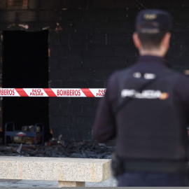 Un agente de policía observa la zona quemada en un local comercial de Alcorcón tras una explosión, a 7 de octubre de 2022, en Alcorcón, Madrid.