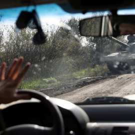 Un conductor pasa junto a un tanque ucraniano que circula por una carretera en la región de Donetsk.