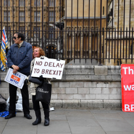 Un manifestante pro-brexit sostiene una pancarta a las puertas del Parlamento en Londres. | Reuters