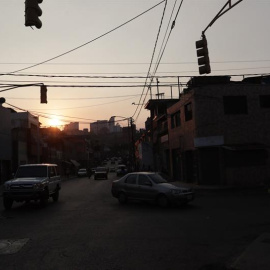 Vehículos transitan por una calle sin alumbrado público por la falta de fluido eléctrico en la zona en Caracas. /RAYNER PEÑA (EFE)