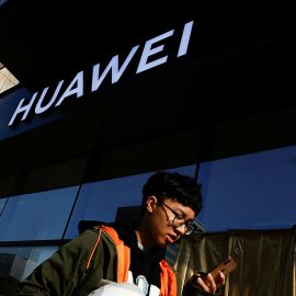 Imagen de un usuario de móvil frente a una tienda de Huawei. REUTERS