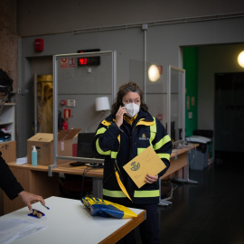 Foto de archivo de una trabajadora de Correos dejando los votos por correo en una mesa electoral de Antic Convent St. Agustí, en Barcelona, a 14 de febrero de 2021.