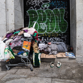 Una persona sin hogar duerme en una calle de Madrid. Imagen de archivo.