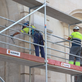 Dos operarios trabajando en el montaje de unos andamios en Sevilla.