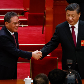 El presidente chino, Xi Jinping, le da la mano a Li Qiang (izquierda), nuevo primer ministro chino, durante la Tercera Sesión Plenaria de la Asamblea Popular Nacional (APN).