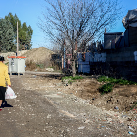 Una mujer camina cargada con bolsas en la Cañada Real, a 31 de diciembre de 2021, en Madrid, (España).