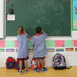 Dos niños pintan en una pizarra el día de inicio del curso en el colegio de la Alameda de Osuna, a 5 de septiembre de 2022, en Madrid (España)