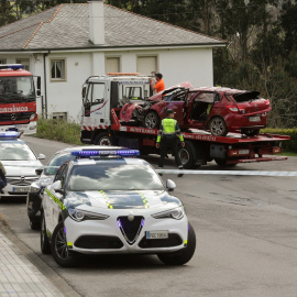 Un Guardia Civil vigila la retirada del coche siniestrado, en el accidente, por una grúa, a 1 de abril de 2023, en Xove (Lugo).