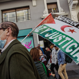 Un hombre sostiene una pancarta en una manifestación contra la violación de derechos en el Sáhara Occidental, a 13 de noviembre de 2021, en Madrid